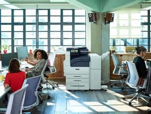 Equipo de trabajo en un espacio abierto con la impresora monocroma Xerox® Serie VersaLink® B7100