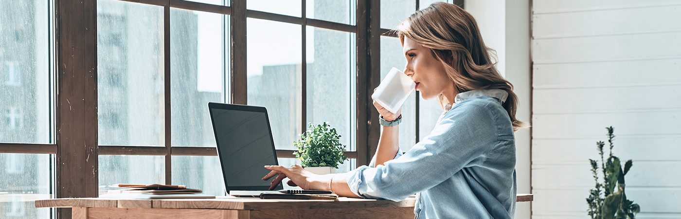 Mujer trabajando en su oficina en casa en su ordenador con la solución Xerox® Docushare® Go