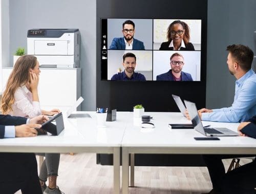 Personas en una sala de reuniones delante de la impresora Xerox® B410