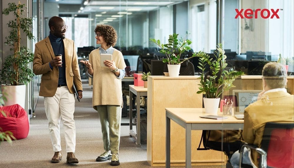 Dos profesionales caminando y hablando en una oficina moderna